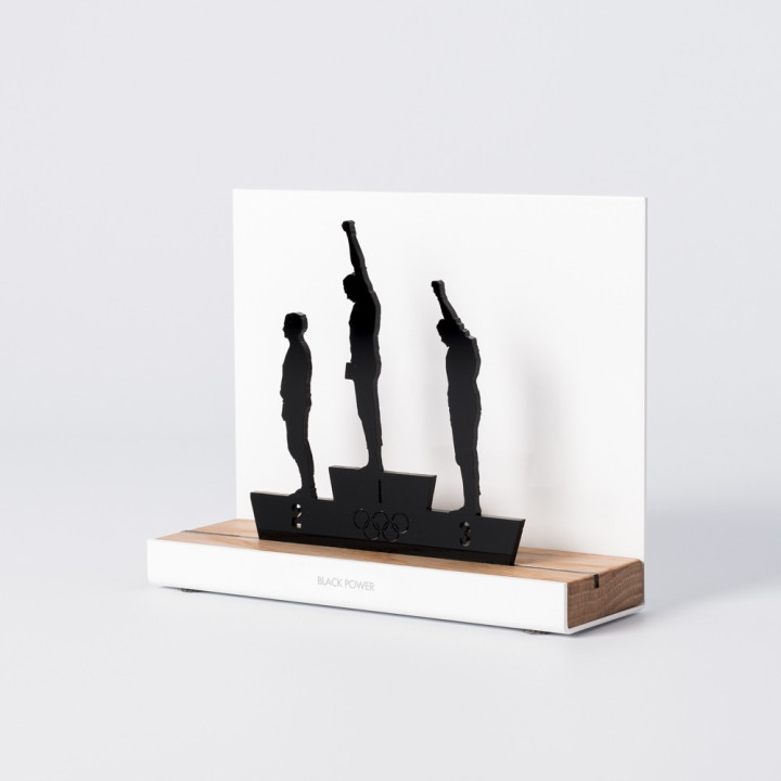 Figure "Black Power · Mexico 68 podium", angled view showing its oak base