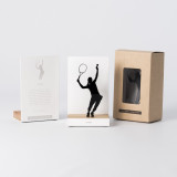 Figure "Tennis · Joueuse au service" à côté de son coffret et de sa boîte cadeau