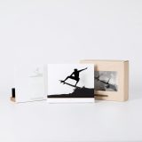 Figura "Surf · Vuelo sobre la ola" junto a su estuche y su caja de regalo