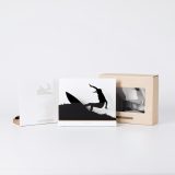 Figura "Surf · Giro con la tabla en alto" junto a su estuche y su caja de regalo
