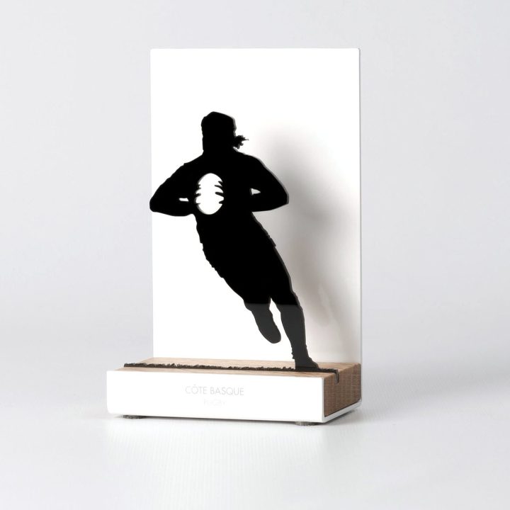 Figura "Rugby · Jugador de frente con balón", vista en perspectiva con su peana de roble