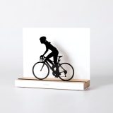 Figure "Cycling · Woman cyclist", angled view showing its oak base