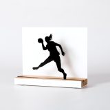 Figura "Balonmano · Jugadora con coleta en salto", vista en perspectiva con su peana de roble