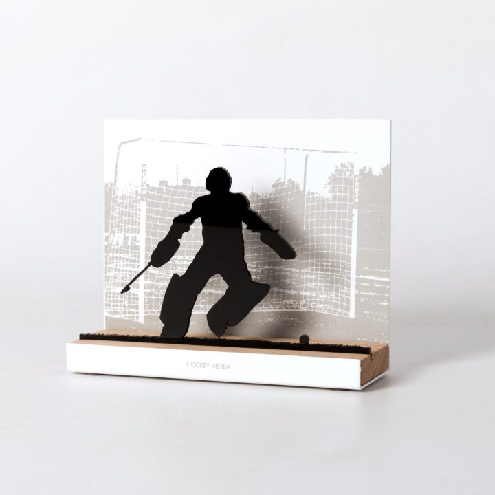 Figure "Field hockey · Goalkeeper making a save", angled view showing its oak base