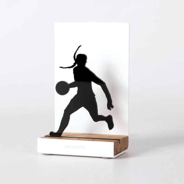 Figura "Baloncesto · Jugadora botando", vista en perspectiva con su peana de roble