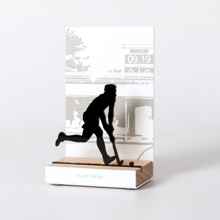Figura "Hockey hierba · Jugador golpeando la bola", vista en perspectiva con su peana de roble