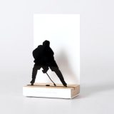 Figure "Hockey sur glace · Joueur de face avec le palet", vue en perspective avec son socle en chêne