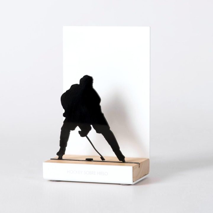 Figura "Hockey hielo · Jugador de frente con el disco", vista en perspectiva con su peana de roble