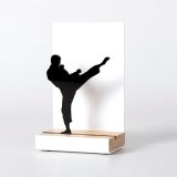 Figura "Karate · Yoko geri kekomi, patada alta", vista en perspectiva con su peana de roble